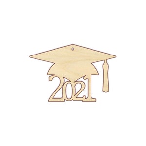 Puede incluir: Corte de madera de un gorro de graduaci&oacute;n con el a&ntilde;o 2021 debajo. El gorro tiene un borla y un agujero para colgar.