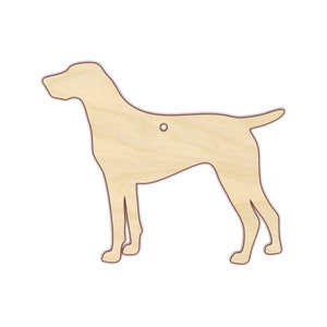 May include: A wooden cutout of a dog, possibly a German Shorthaired Pointer, in a standing position. The cutout is light brown and has a hole in the top for hanging.
