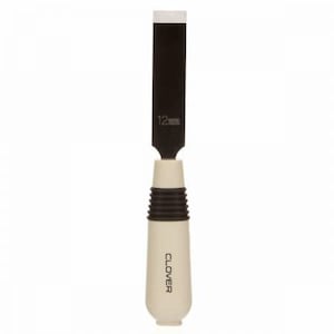 Puede incluir: Una herramienta de talla de madera en blanco y negro con un mango de plástico blanco. El mango tiene la palabra "CLOVER" impresa. La hoja está etiquetada como "12 mm".
