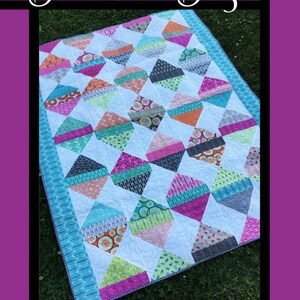 May include: A colorful quilt pattern called "Diamond Daze" by Tricia Lynn Maloney for Villa Rosa Designs. The quilt features a diamond pattern with a variety of bright colors and patterns.