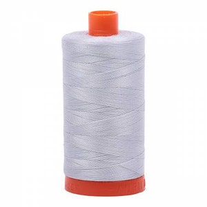 May include: A spool of light gray thread with an orange plastic top and bottom.