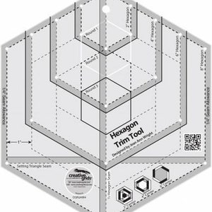 Könnte beinhalten: Ein sechseckiges Quilting-Werkzeug mit einer Nahtzugabe von 6,35 mm. Das Werkzeug ist so konzipiert, dass Quilter ihre Hexagone auf die richtige Größe zuschneiden können. Das Werkzeug besteht aus klarem Kunststoff und hat ein gedrucktes Gittermuster. Das Werkzeug ist mit "Hexagon Trim Tool" und "Designed by Jean Ann Wright" beschriftet.