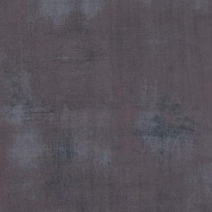 Può includere: Un tessuto tinta unita grigio scuro con una texture leggermente marmorizzata. Il tessuto ha un aspetto leggermente sbiadito, vintage.
