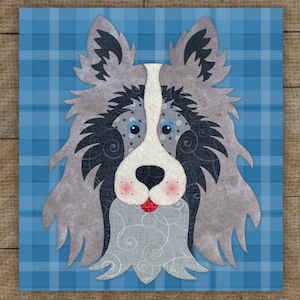 May include: A square, decorative artwork featuring a stylized dog's face. The dog has gray and black fur, a white snout, and blue eyes. The background is a blue plaid pattern. The dog's face has decorative swirls.