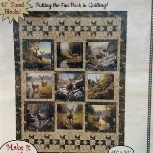 May include: A fabric panel featuring a deer-themed quilt design. The quilt has nine rectangular panels with deer scenes, framed by a border with star patterns. The text "Fabric Cafe" and "Marquee" are visible. The quilt measures 40 inches by 54 inches.