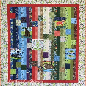 May include: A colorful patchwork quilt with a red border and a floral patterned edge. The quilt features various animal illustrations, including a bear, fox, and fish, set against a backdrop of blue, green, and red stripes. The text "FrontPorchQuiltShop.com" is visible.