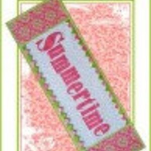 Può includere: Un runner da tavolo bianco con un bordo rosa e verde. La parola "Summertime" è ricamata in rosa sul runner.