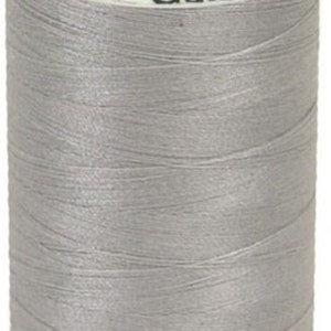 May include: A spool of Gütermann thread in colour 102, a light grey colour. The spool is labelled with the brand name and the colour number. The spool contains 500 metres (547 yards) of thread.