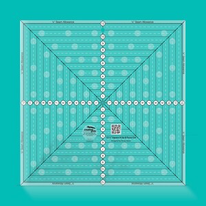 May include: A square, turquoise quilting ruler with white markings and a grid pattern. The ruler has measurements from 1 to 12, with dotted lines and text that reads "1/4" Seam Allowance". The text "12 1/2" Square It Up & Fussy Cut" is also visible.