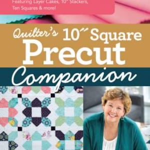 May include: A book titled "Quilter's 10" Square Precut Companion" with a colourful quilt on the cover and a woman smiling in the background. The book is a handy reference guide with 20+ block patterns, featuring layer cakes, 10" stackers, ten squares, and more.