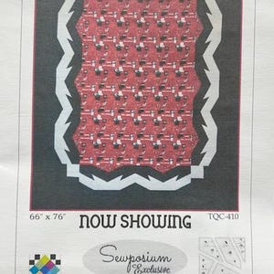 May include: A printed quilt pattern with a red and white patterned center, framed by a black border and a white zigzag design. The text "NOW SHOWING" is displayed, along with the dimensions 66" x 76". The pattern is by Karen Montgomery.