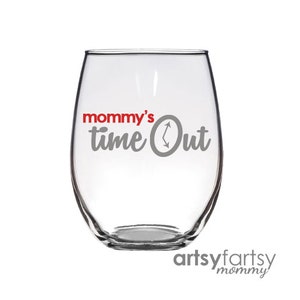 以下が含まれることがあります： 透明なガラス製のワイングラスに、「mommy's time out」という文字がグレーと赤で書かれています。文字の中に時計の文字盤が含まれています。