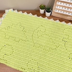 a crocheted blanket sitting on top of a wooden table
