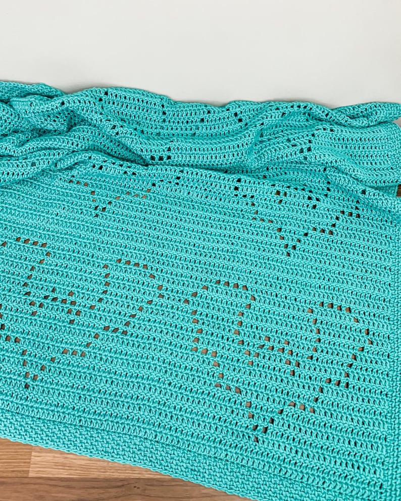 a blue crocheted blanket on a wooden desk