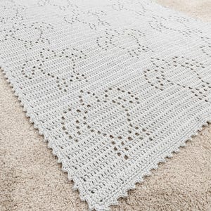 May include: A crocheted throw blanket in a light gray color with a diamond pattern.