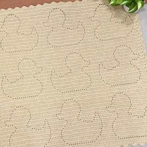Handmade filet crochet baby blanket, with rubber ducky designs. Blanket is made in butter yellow color yarn and laid out on a king sized bed. Perfect gift for newborns or new parents.