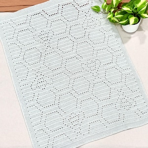 May include: A light blue crocheted baby blanket with a delicate diamond pattern.