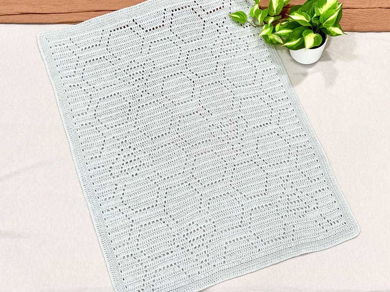 May include: A light blue crocheted baby blanket with a delicate diamond pattern.