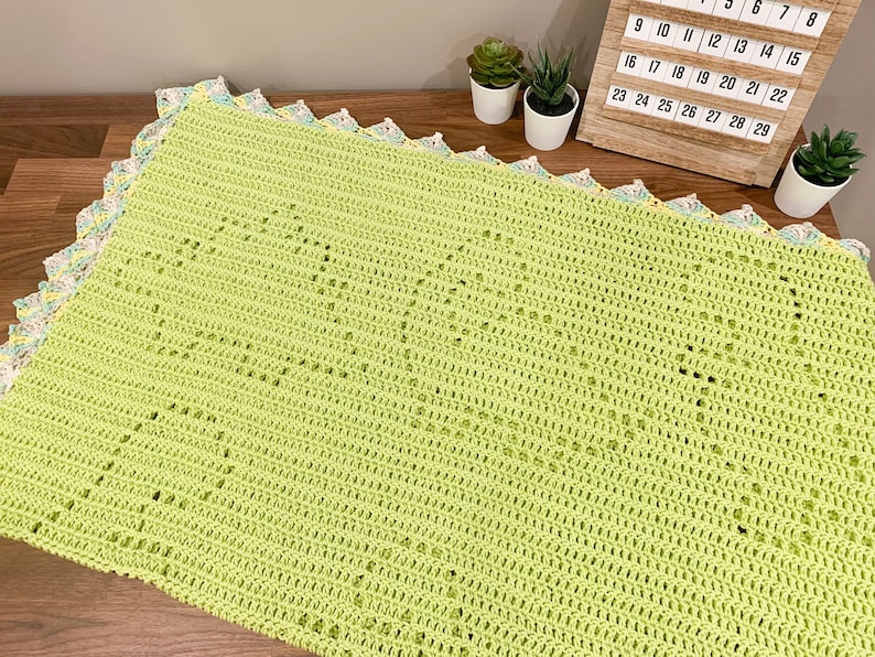 a crocheted blanket sitting on top of a wooden table