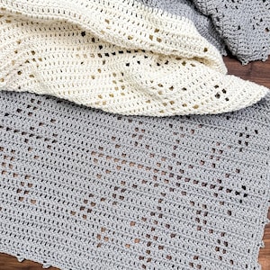 a crocheted blanket laying on top of a wooden floor