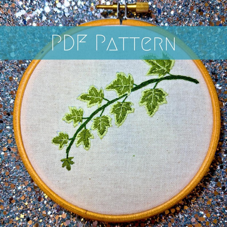 K&ouml;nnte beinhalten: Ein runder Stickrahmen aus Holz mit wei&szlig;em Stoff, der ein handgesticktes Motiv einer gr&uuml;nen Efeuranke mit detaillierten Bl&auml;ttern zeigt. Der Text PDF PATTERN ist in Wei&szlig; &uuml;ber die Mitte des Bildes auf den Stickrahmen gedruckt.