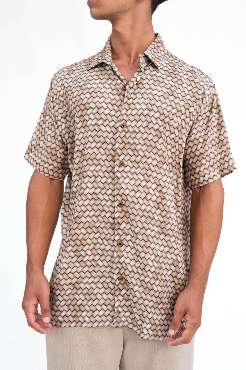 May include: Short-sleeved button-down shirt with a woven basket-like pattern in shades of tan and brown. The shirt has a classic collar and wooden buttons. The fabric appears lightweight and suitable for warm weather.