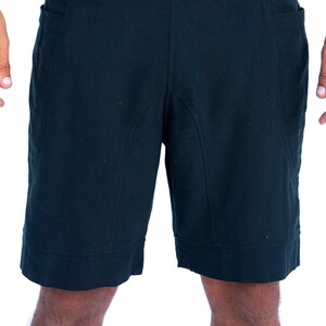 Puede incluir: Un pantal&oacute;n corto negro con un dise&ntilde;o sencillo y dos bolsillos. El pantal&oacute;n corto tiene una pierna recta y un dobladillo con vuelta.