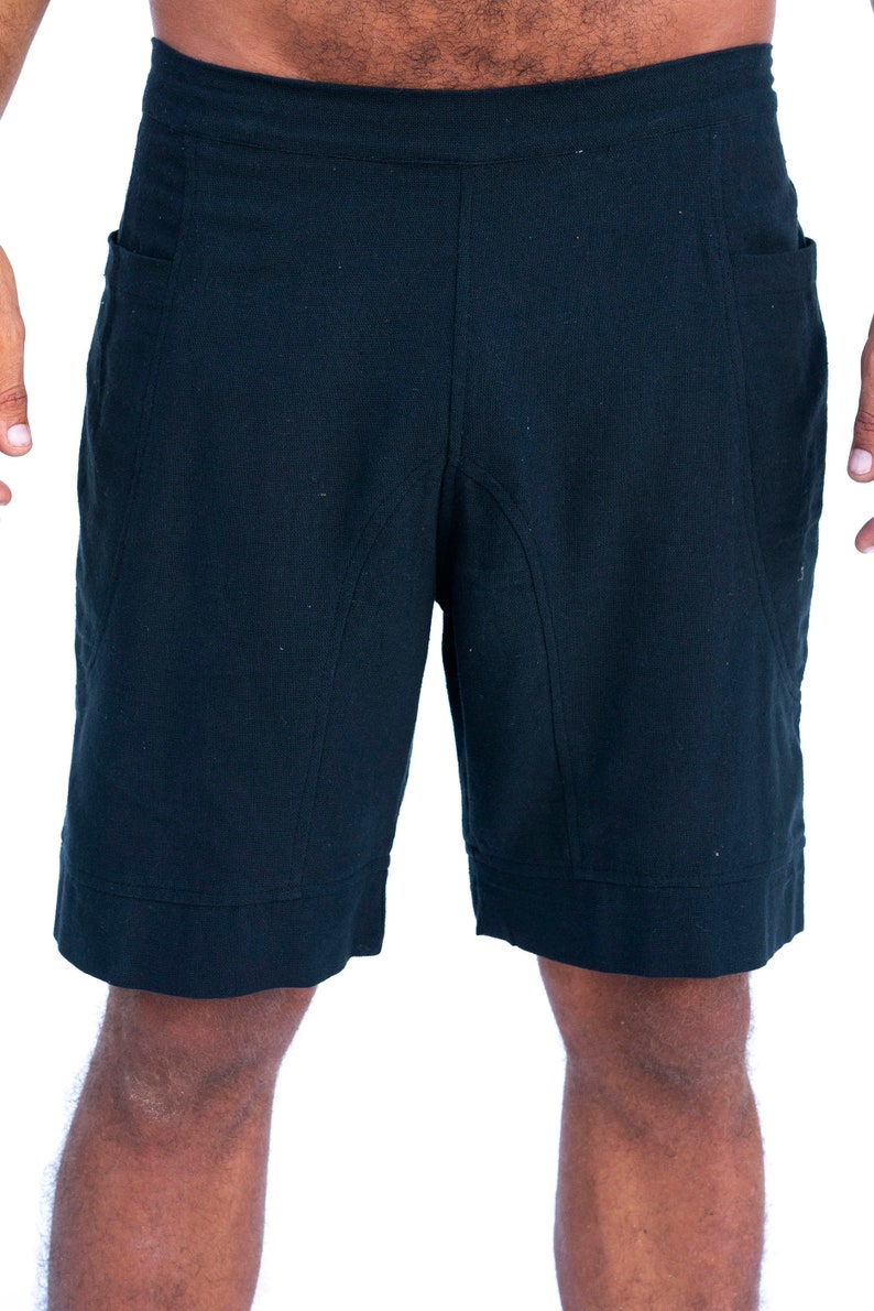 Puede incluir: Un pantal&oacute;n corto negro con un dise&ntilde;o sencillo y dos bolsillos. El pantal&oacute;n corto tiene una pierna recta y un dobladillo con vuelta.