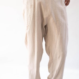 May include: A pair of beige linen trousers with a drawstring waist and cuffed legs.