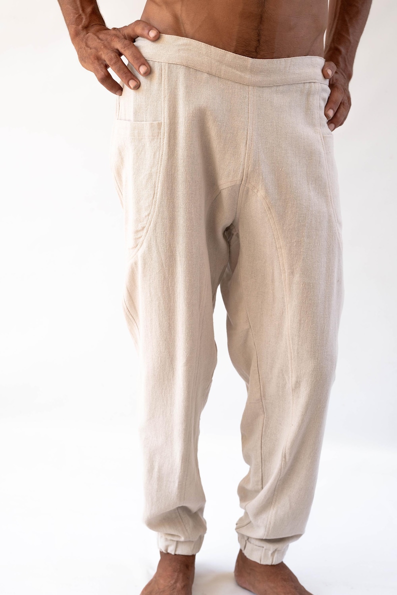 May include: A pair of beige linen trousers with a drawstring waist and cuffed legs.