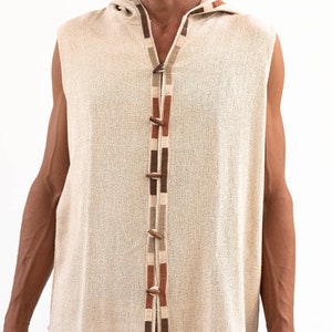 May include: A sleeveless hooded vest with a brown, beige, and orange trim. The vest has a button closure down the front.