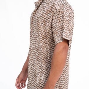 May include: Short-sleeved button-down shirt with a woven basket-like pattern in shades of beige and brown. The shirt has a classic collar and is made of a lightweight fabric, suitable for warm weather. The shirt is a casual wear.