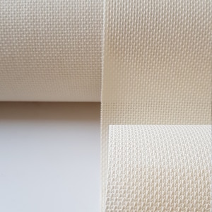 May include: A roll of white Aida cloth, a type of fabric used for cross-stitch embroidery.