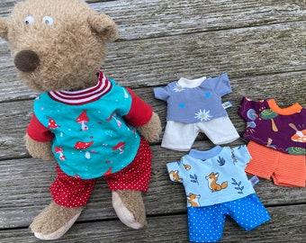 May include: Four sets of pajamas for stuffed animals. The pajamas are in different colors and patterns, including mushrooms, flowers, foxes, and polka dots. The pajamas are made of soft, comfortable fabric and are perfect for cuddling up in.