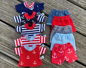 May include: A set of miniature clothing for dolls, featuring red, blue, and white striped and anchor-patterned shirts and shorts. The clothing is made of cotton fabric and has a nautical theme.