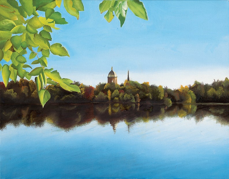 May include: A painting of a lake with a building and a spire in the distance, surrounded by trees. The lake is reflecting the sky and the trees. The painting is framed by a branch of green leaves.