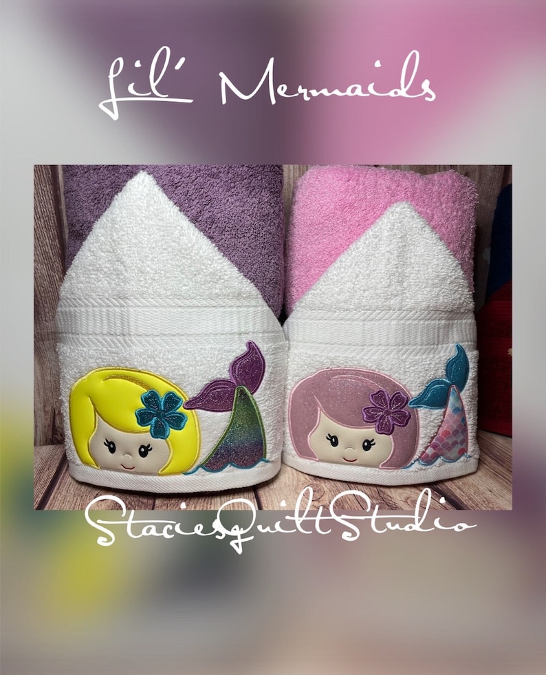 May include: Two hooded towels with embroidered mermaid designs. One mermaid has yellow hair and a purple tail, the other has pink hair and a blue tail. The towels are white with purple and pink accents. The text "Lil' Mermaids" is at the top of the image and "Stacie's Quilt Studio" is at the bottom.