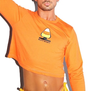 May include: Orange long-sleeved cropped t-shirt with a candy corn graphic and the text "BUTT STUFF".