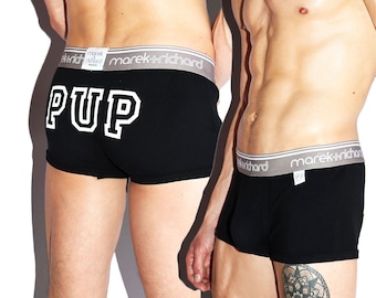 May include: Black boxer briefs with a white elastic waistband that says "marek+richard" and a white "PUP" graphic on the back.