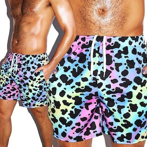 May include: Rainbow tie-dye print swim trunks with a black leopard print pattern. The swim trunks have a drawstring waist.