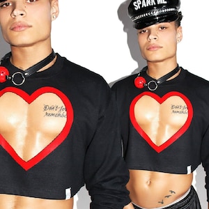 May include: Black cropped sweatshirt with a red heart cutout revealing a printed image of a chest. The text "Don't forget to remember" is printed inside the heart.