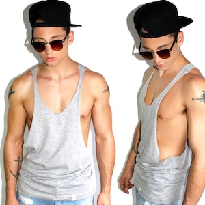 May include: A gray sleeveless shirt with a scoop neck and a loose fit. The shirt is made of a soft, comfortable fabric and has a relaxed, casual style.