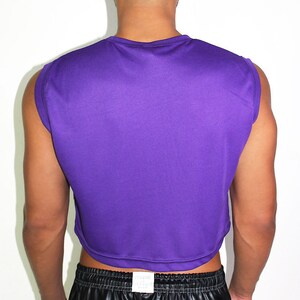 May include: A purple sleeveless cropped top with a round neckline. The top is made of a soft, stretchy fabric and has a relaxed fit.