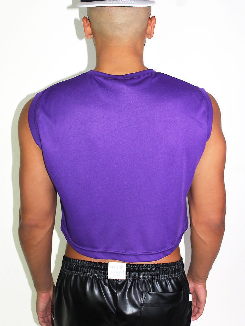 May include: A purple sleeveless cropped top with a round neckline. The top is made of a soft, stretchy fabric and has a relaxed fit.