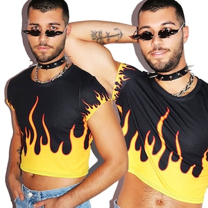 May include: A black cropped t-shirt with a yellow and red flame design. The shirt has short sleeves and a round neckline. The model is wearing a silver chain necklace and a black choker with silver spikes.
