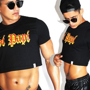 May include: Black cropped t-shirt with short sleeves and the text "Si Papi" in red and yellow lettering.