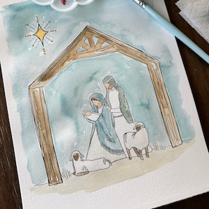 May include: A watercolor painting of the nativity scene with Mary, Joseph, and baby Jesus. The scene is set in a stable with a wooden frame and a star above. There are two white sheep in the foreground.