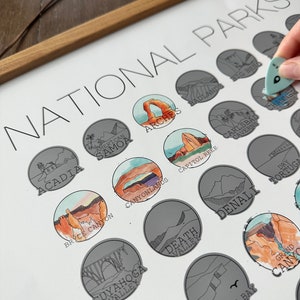May include: A white poster with the title "National Parks" printed in black. The poster features a collection of illustrated national park logos, each with a unique design and color scheme. The logos are arranged in a circular pattern, with the names of the parks printed below each logo.
