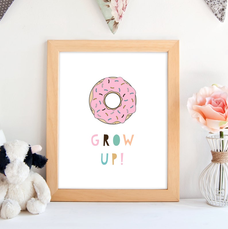 Pode incluir: Uma impress&atilde;o emoldurada com um donut rosa com granulado e o texto "GROW UP!" em letras coloridas.