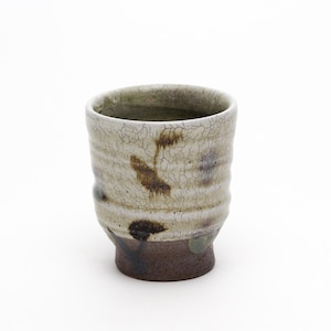 May include: A handcrafted ceramic cup with a textured, off-white exterior and a dark brown base. The cup features subtle brown and blue-grey accents, and measures approximately 4 inches in height. The design suggests a rustic or artisanal aesthetic.